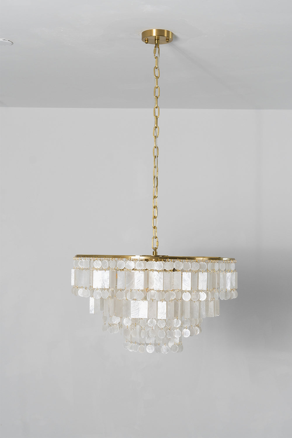 Seraphina Capiz Cascade Metal Chandelier hanging from the ceiling with elegant capiz shell discs.