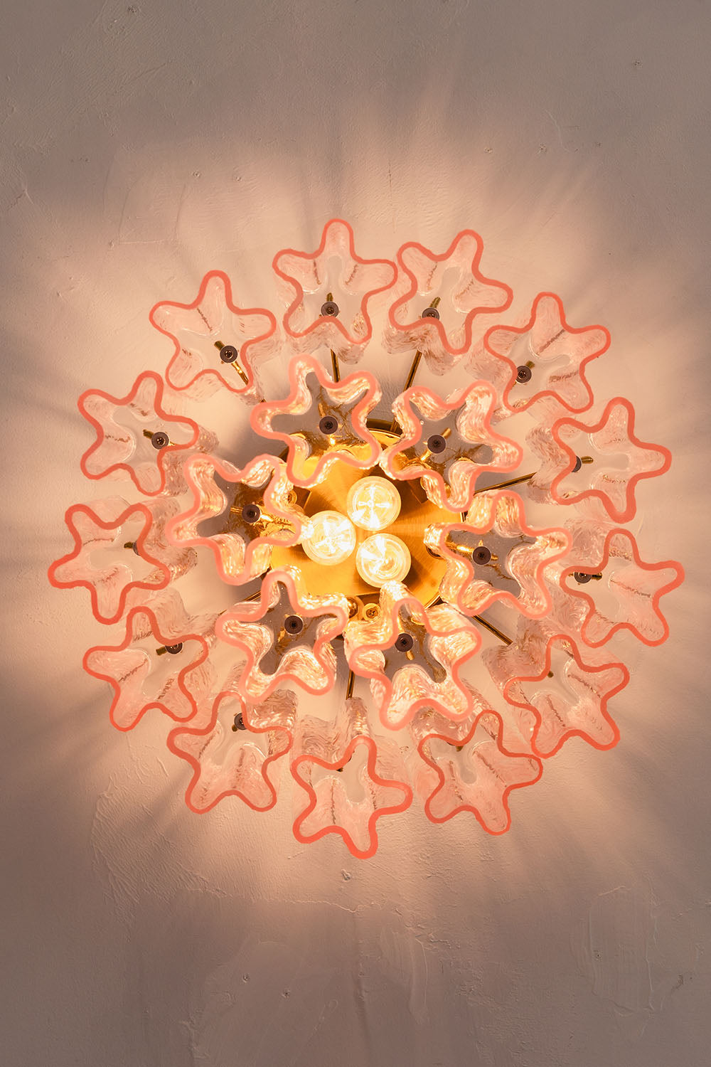 Seraphine Starburst Glass Tube Ceiling Light | Pink Glass and Brass | Bottom-up perspective showing the starburst light shadow pattern on the ceiling | vexa lamps