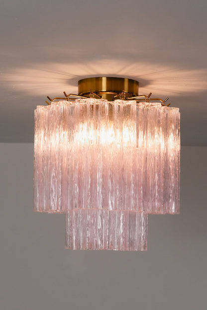 Seraphine Starburst Glass Tube Ceiling Light | Pink Glass and Brass | Studio display showing the chandelier glowing warmly against a dark grey wall | vexa lamps