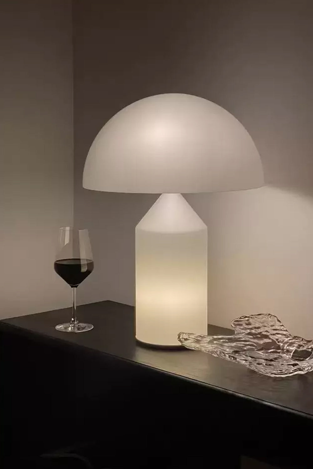 Solene Domed Glass Table Lamp | White Frosted Glass | Lit up on a dark shelf next to a glass of red wine creating a warm atmosphere | vexa lamps