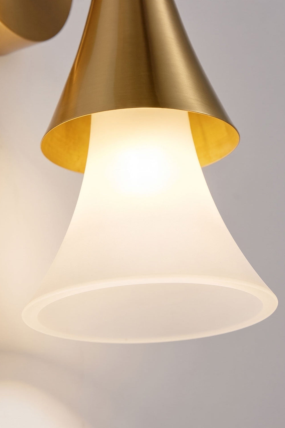 Sylvain Modern Torch Wall Sconce featuring a trumpet-shaped frosted glass shade and metallic accent.