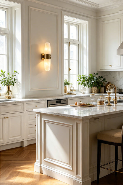 Theron Linear Alabaster Wall Lamp | Alabaster, Metal | Mounted on a white wall in a bright luxury kitchen area near a pristine white marble island counter | vexa lamps