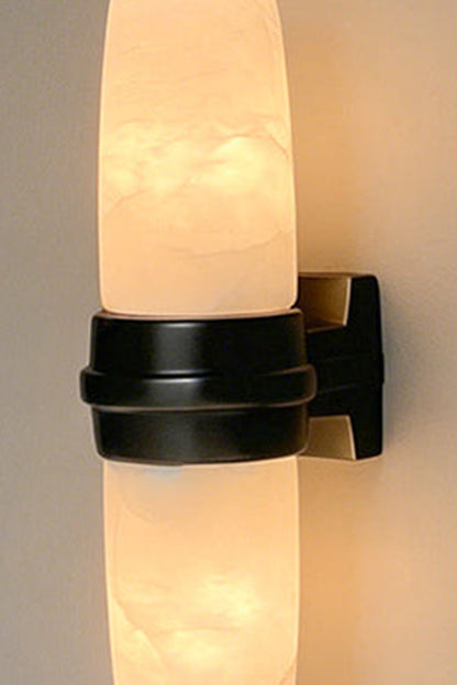 Theron Linear Alabaster Wall Lamp | Alabaster, Metal | Detailed close-up view of the lit dark base variant showcasing the soft organic clouds and lines within the stone | Detail shot | vexa lamps