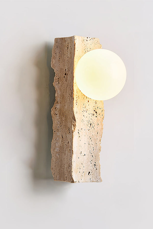Angled perspective of lit stone block wall lamp | Yellow Travertine, Metal, Glass | Showing the warm glow and organic stone form | vexa lamps