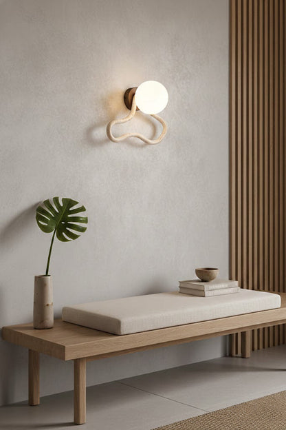 Travertine flow sconce in a zen-inspired space | Travertine, Glass, Wood | Above a wooden bench on a textured wall | vexa lamps