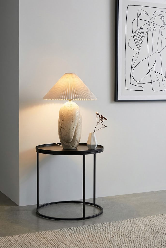 Sculptural travertine lamp on metal stand | Travertine, Fabric | On a black round side table against a grey wall | vexa lamps