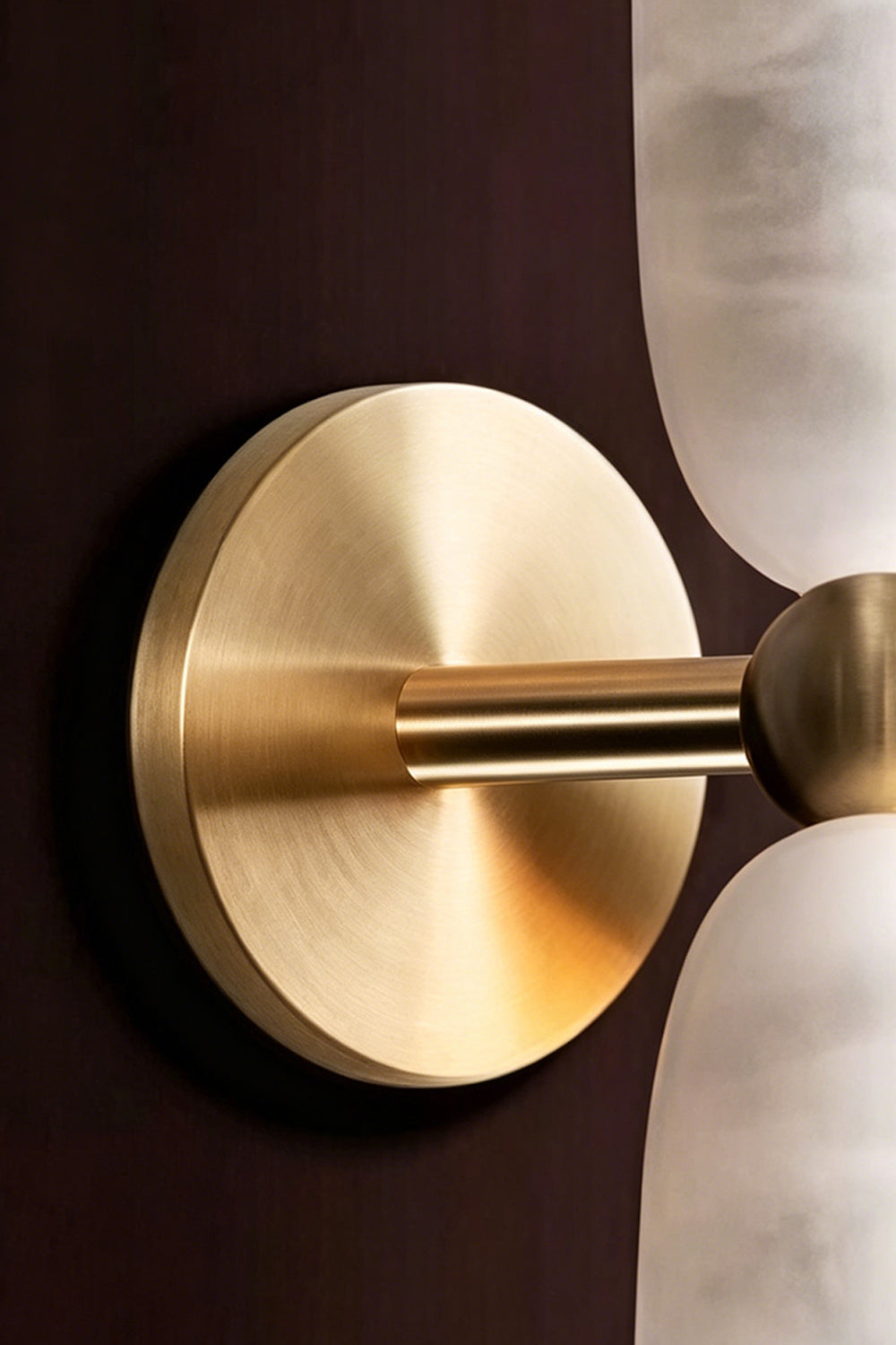 Vesperal Axis Alabaster Wall Lamp | Alabaster, Metal | Close-up of the circular gold metal mounting plate and connecting arm | Detail shot | vexa lamps